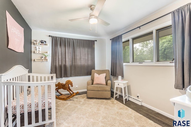 1002 N Carol St, Luverne, MN 56156 - bedroom with baseboards, wood finished floors, a crib, and a ceiling fan