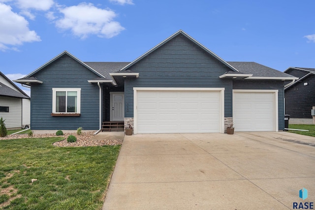110 Skyline Dr, Valley Springs, SD 57068 - view of front of home featuring concrete driveway, a garage, a front yard, and stone siding