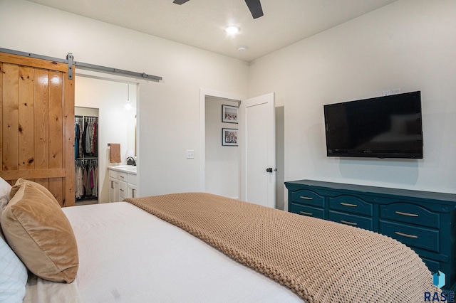 110 Skyline Dr, Valley Springs, SD 57068 - bedroom featuring a walk in closet, a closet, a sink, ceiling fan, and a barn door