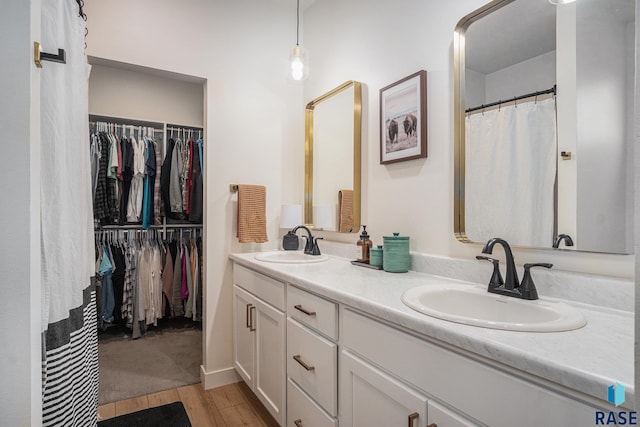 110 Skyline Dr, Valley Springs, SD 57068 - bathroom featuring double vanity, wood finished floors, and a spacious closet