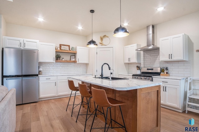 110 Skyline Dr, Valley Springs, SD 57068 - kitchen featuring wall chimney exhaust hood, stainless steel appliances, a sink, open shelves, and light wood finished floors