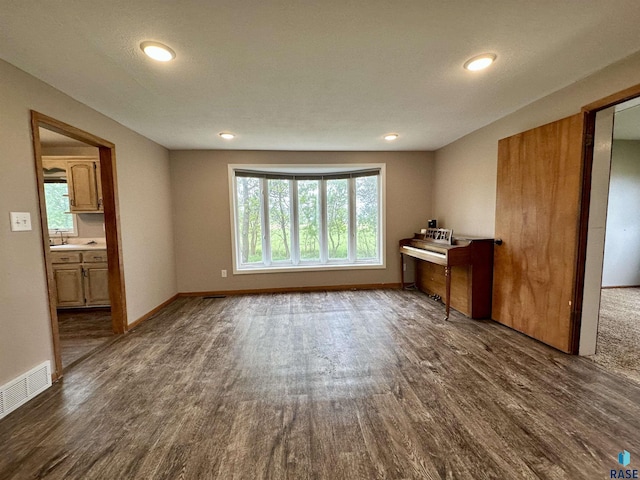210 160th Ave, Edgerton, MN 56156 - unfurnished living room featuring dark wood-style floors, recessed lighting, baseboards, and a sink