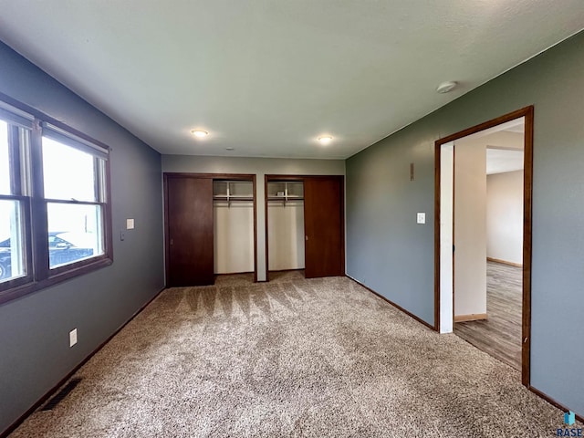 210 160th Ave, Edgerton, MN 56156 - unfurnished bedroom featuring multiple closets, light colored carpet, and baseboards