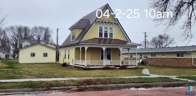 120 Main St, Scotland, SD 57059 - view of front of home featuring covered porch, a front lawn, metal roof, and central air condition unit