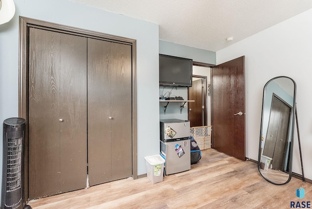 unfurnished bedroom featuring light wood finished floors and a closet