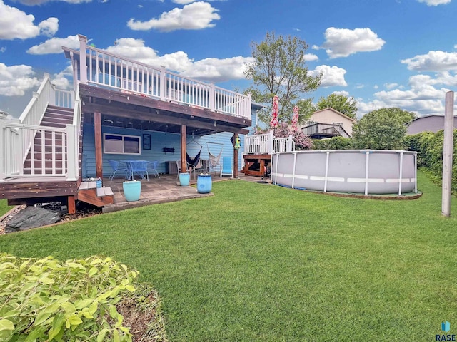 rear view of property with a deck, a yard, stairway, and an outdoor pool