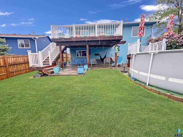 rear view of property featuring a deck, a patio area, and stairway