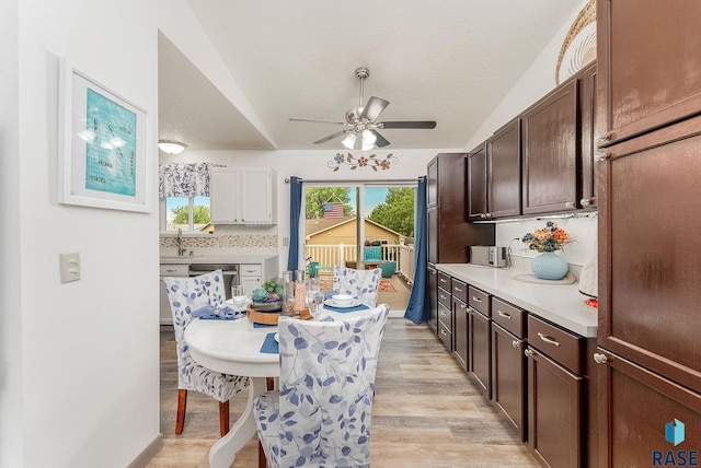 dining room with ceiling fan, light wood finished floors, and a textured ceiling