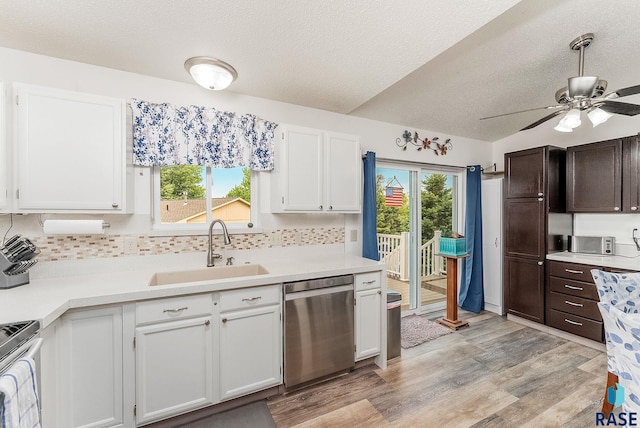 kitchen featuring appliances with stainless steel finishes, a sink, a textured ceiling, light countertops, and tasteful backsplash