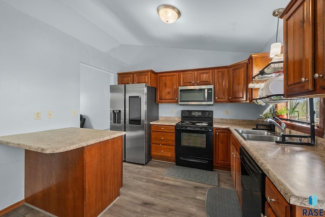 kitchen featuring black appliances, a sink, lofted ceiling, and brown cabinetry