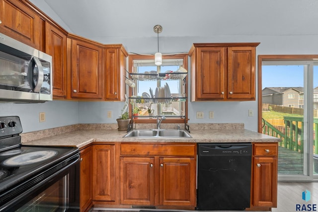 kitchen with black appliances, a sink, light countertops, and brown cabinets