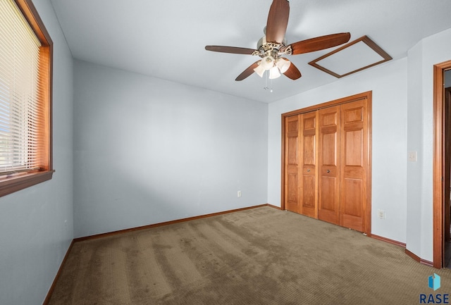 unfurnished bedroom with carpet flooring, baseboards, a closet, and a ceiling fan
