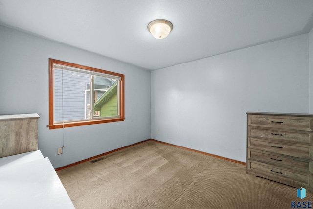 unfurnished bedroom featuring carpet flooring and baseboards