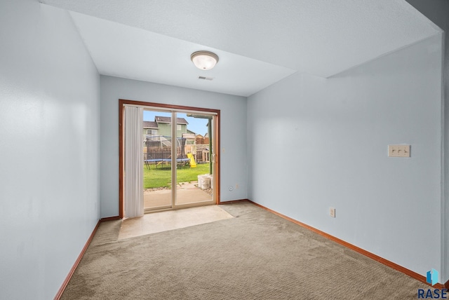 spare room featuring light colored carpet and baseboards