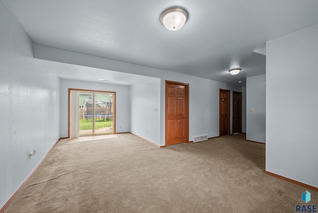 spare room featuring carpet floors and baseboards
