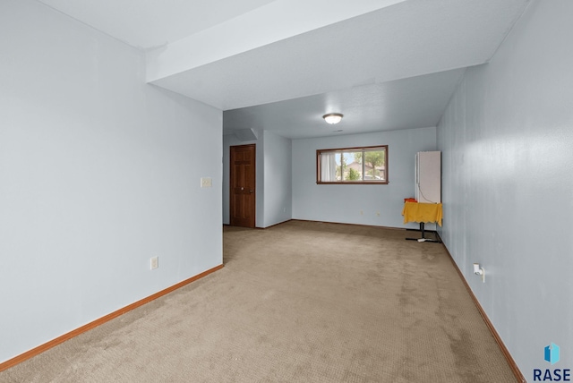 carpeted empty room featuring baseboards