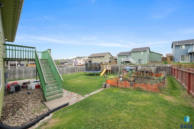 view of yard with a trampoline, a residential view, stairs, a playground, and central AC unit