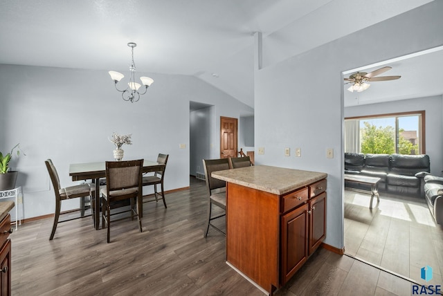 kitchen featuring a chandelier, a kitchen bar, dark wood-type flooring, lofted ceiling, and light countertops