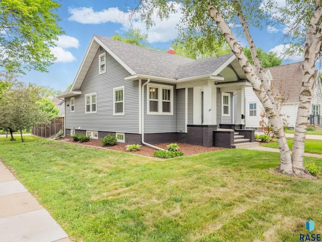 view of front facade featuring a front lawn and roof with shingles