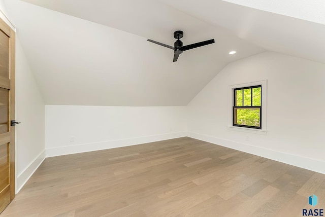 additional living space featuring a ceiling fan, vaulted ceiling, baseboards, light wood-style flooring, and recessed lighting