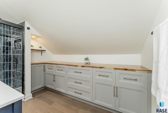 bathroom with vaulted ceiling and wood finished floors