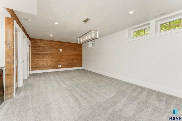 carpeted empty room with wood walls, baseboards, recessed lighting, and a smoke detector