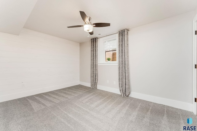empty room featuring a ceiling fan, carpet, and baseboards