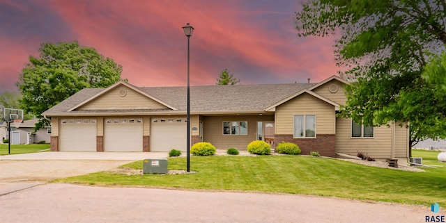 811 Southview Dr, Larchwood, IA 51241 - single story home with brick siding, a yard, an attached garage, and concrete driveway