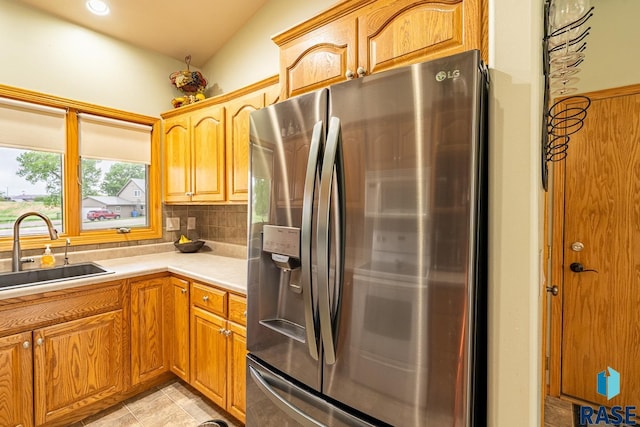 811 Southview Dr, Larchwood, IA 51241 - kitchen featuring stainless steel fridge, a sink, tasteful backsplash, light countertops, and light tile patterned floors