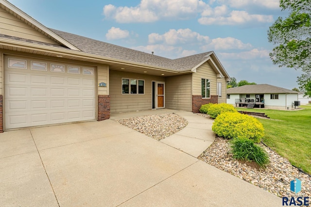 811 Southview Dr, Larchwood, IA 51241 - ranch-style house featuring brick siding, concrete driveway, a garage, and a front lawn