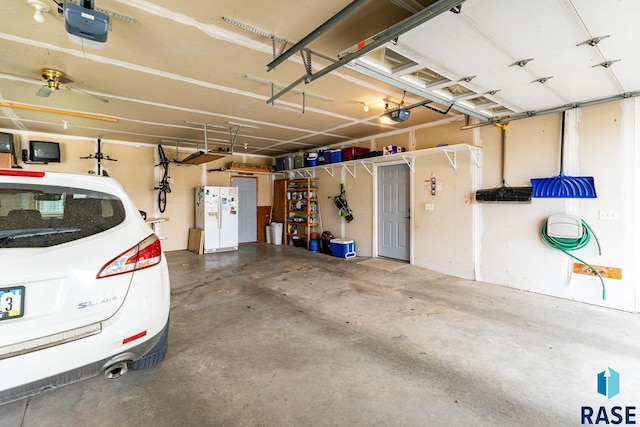 811 Southview Dr, Larchwood, IA 51241 - garage featuring a garage door opener and white refrigerator with ice dispenser