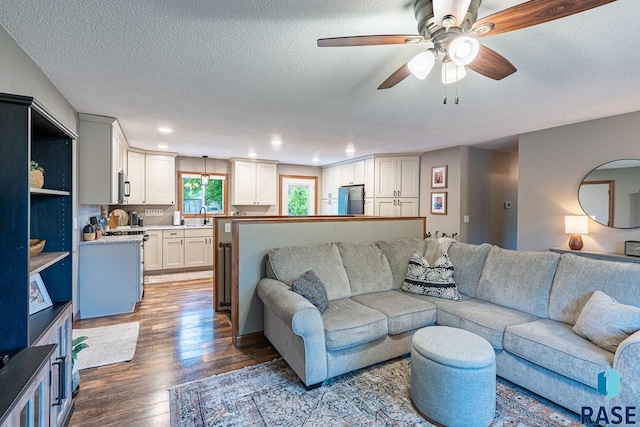 living area featuring wood finished floors, ceiling fan, a textured ceiling, and recessed lighting