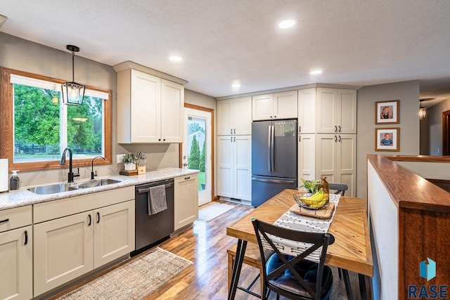 kitchen with stainless steel appliances, a sink, healthy amount of natural light, light wood-type flooring, and recessed lighting