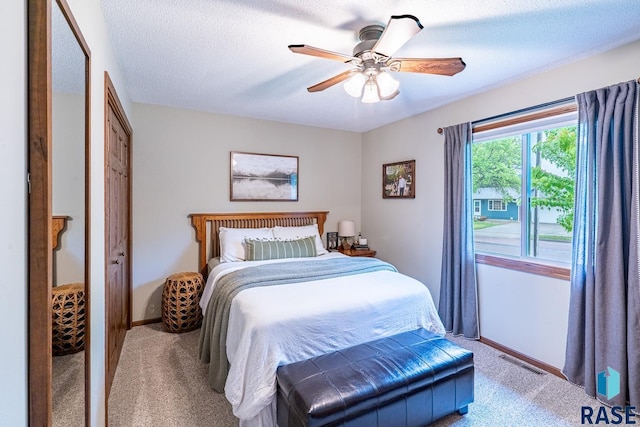 bedroom featuring light carpet, baseboards, and a ceiling fan