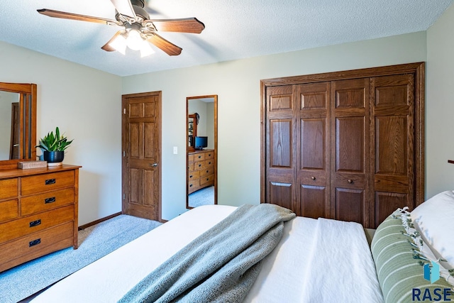 carpeted bedroom featuring a ceiling fan, a textured ceiling, and baseboards