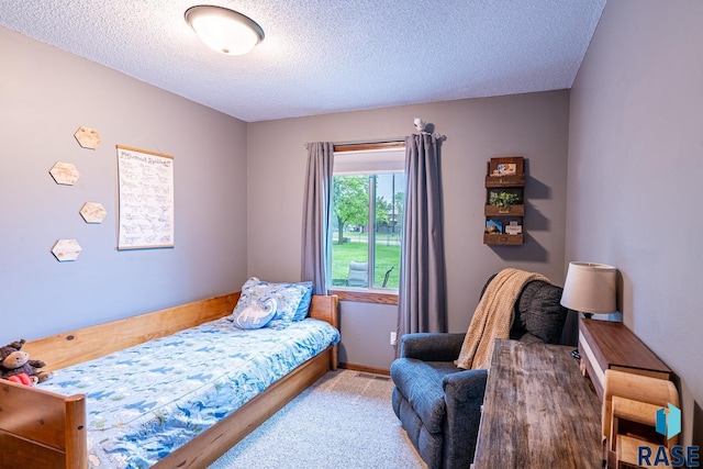 bedroom featuring a textured ceiling and carpet floors