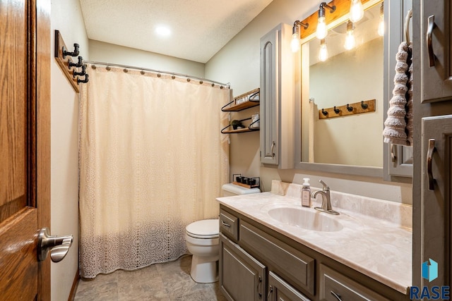 bathroom with toilet, vanity, and a textured ceiling