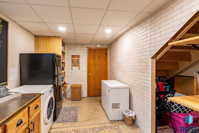 laundry room with brick wall, washer and dryer, and recessed lighting