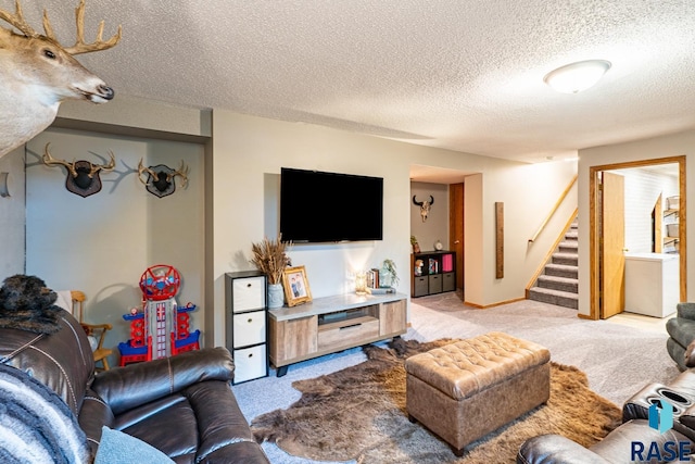 living area with light colored carpet, stairway, washer / dryer, and a textured ceiling