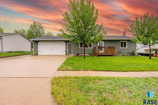 view of front facade featuring a garage, driveway, and a yard