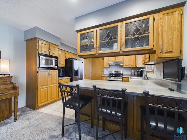 2904 E 52nd St, Sioux Falls, SD 57103 - kitchen with stainless steel appliances, a sink, under cabinet range hood, a peninsula, and light countertops