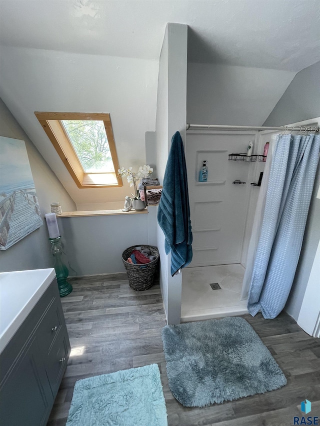 401 W 16th St, Tyndall, SD 57066 - full bath featuring a skylight, vaulted ceiling, a stall shower, wood finished floors, and a freestanding bath