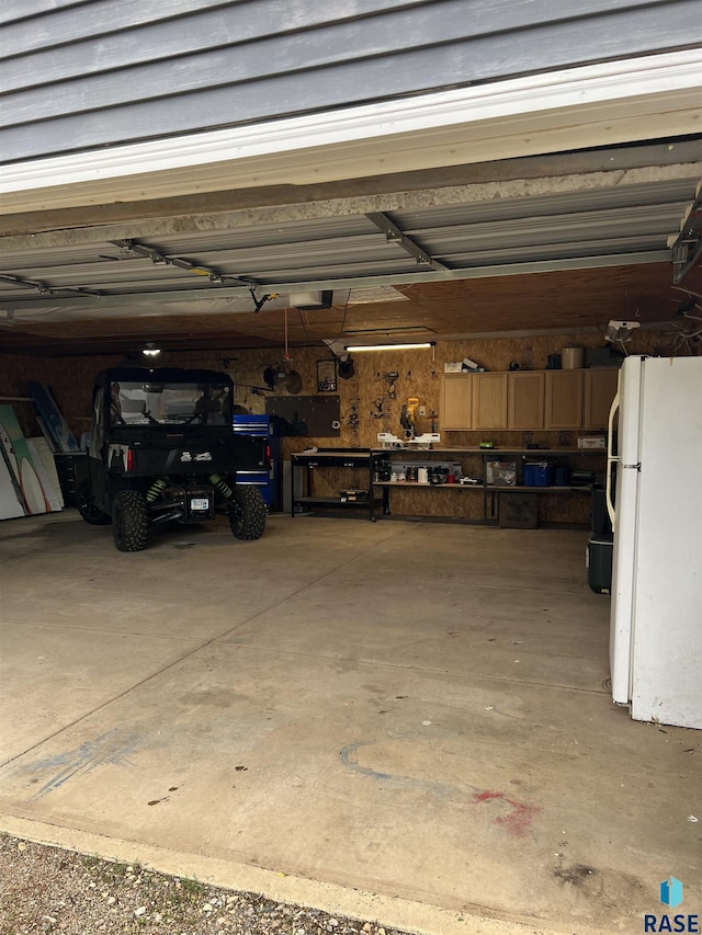 401 W 16th St, Tyndall, SD 57066 - garage featuring freestanding refrigerator and a garage door opener