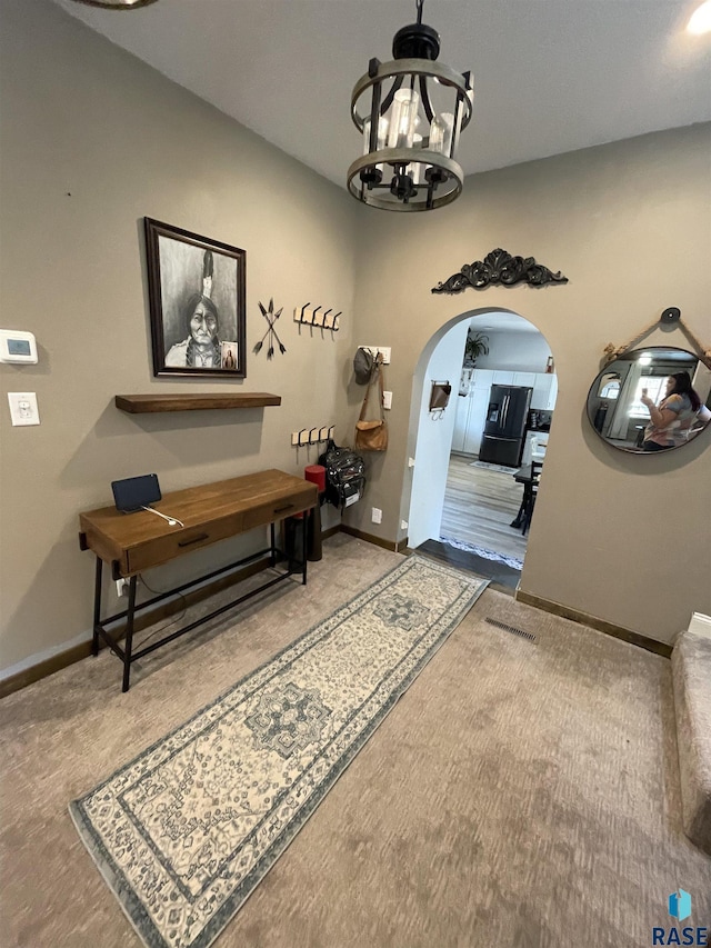 401 W 16th St, Tyndall, SD 57066 - hall with arched walkways, a chandelier, baseboards, and carpet floors