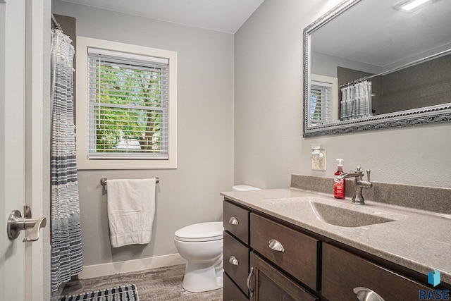 1034 N Elmwood Ave, Luverne, MN 56156 - bathroom featuring vanity, toilet, wood finished floors, baseboards, and a shower with curtain