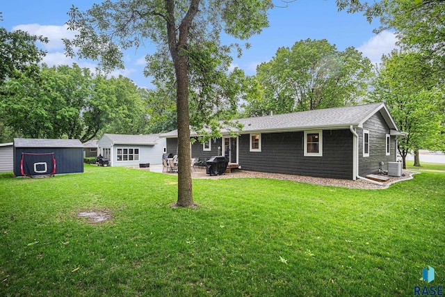 1034 N Elmwood Ave, Luverne, MN 56156 - back of property featuring central AC, a lawn, and a patio area