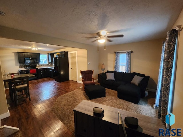 912 N Spring Ave, Sioux Falls, SD 57104 - living area with dark wood-style flooring, a ceiling fan, baseboards, and a textured ceiling