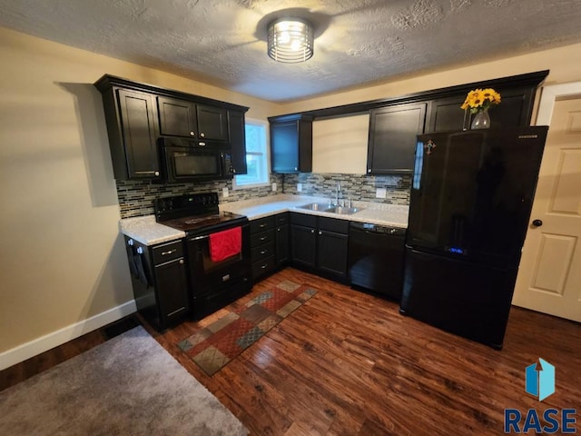 912 N Spring Ave, Sioux Falls, SD 57104 - kitchen with black appliances, a sink, light countertops, decorative backsplash, and dark wood-style flooring