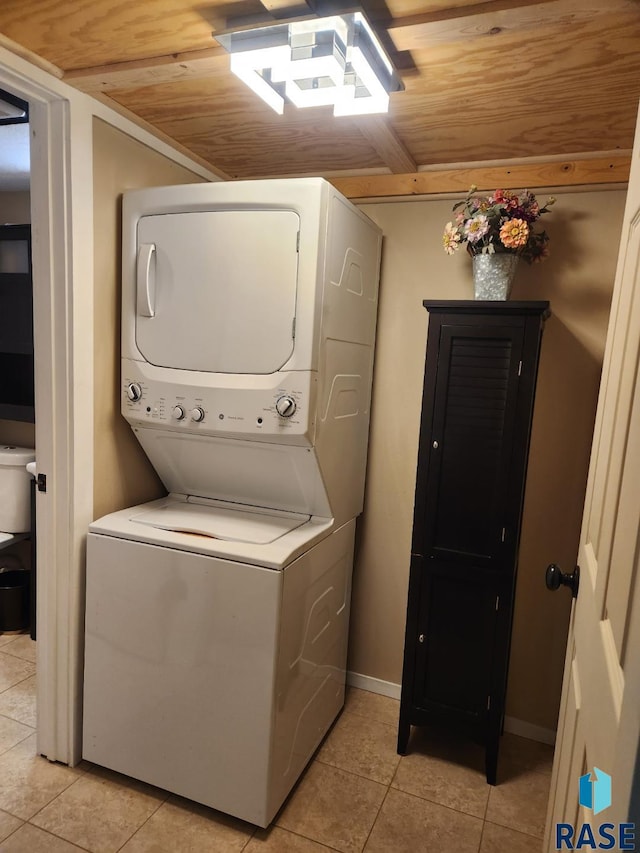 912 N Spring Ave, Sioux Falls, SD 57104 - washroom featuring stacked washer and clothes dryer, light tile patterned floors, wooden ceiling, and baseboards