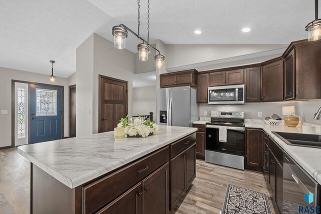 525 Quartzite Ave, Tea, SD 57064 - kitchen featuring stainless steel appliances, a sink, lofted ceiling, light wood finished floors, and dark brown cabinetry